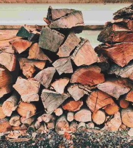 Difference between firewood and braai wood shown through stacked wood prepared for heating and outdoor cooking.