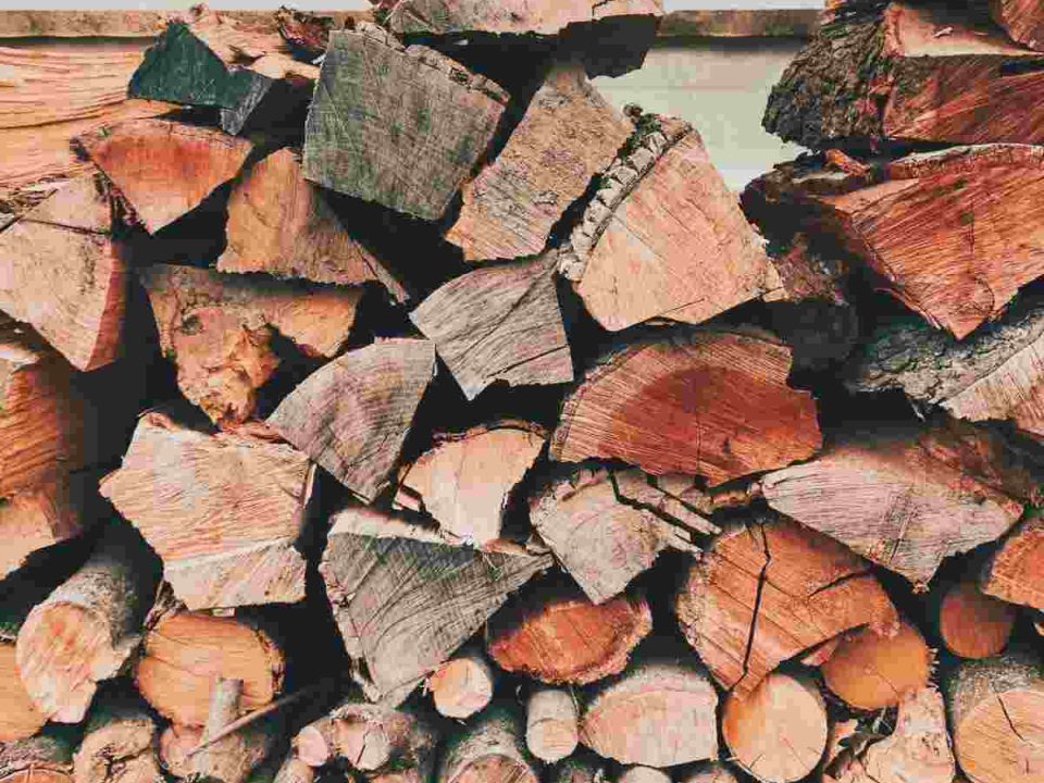 Difference between firewood and braai wood shown through stacked wood prepared for heating and outdoor cooking.